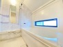 2号棟 浴室は白を基調とした中に、タイル調の壁を採用することで、明るい上で落ち着く空間を実現しております。日々の疲れをこちらの浴室で癒してくださいませ。